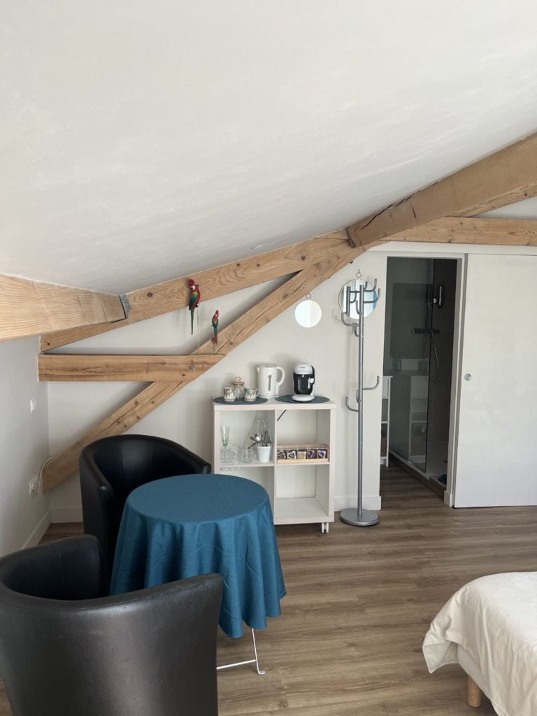 Vintage chambre avec poutres en bois et coin petit déjeuner au Les Voûtes de Villebourbon.